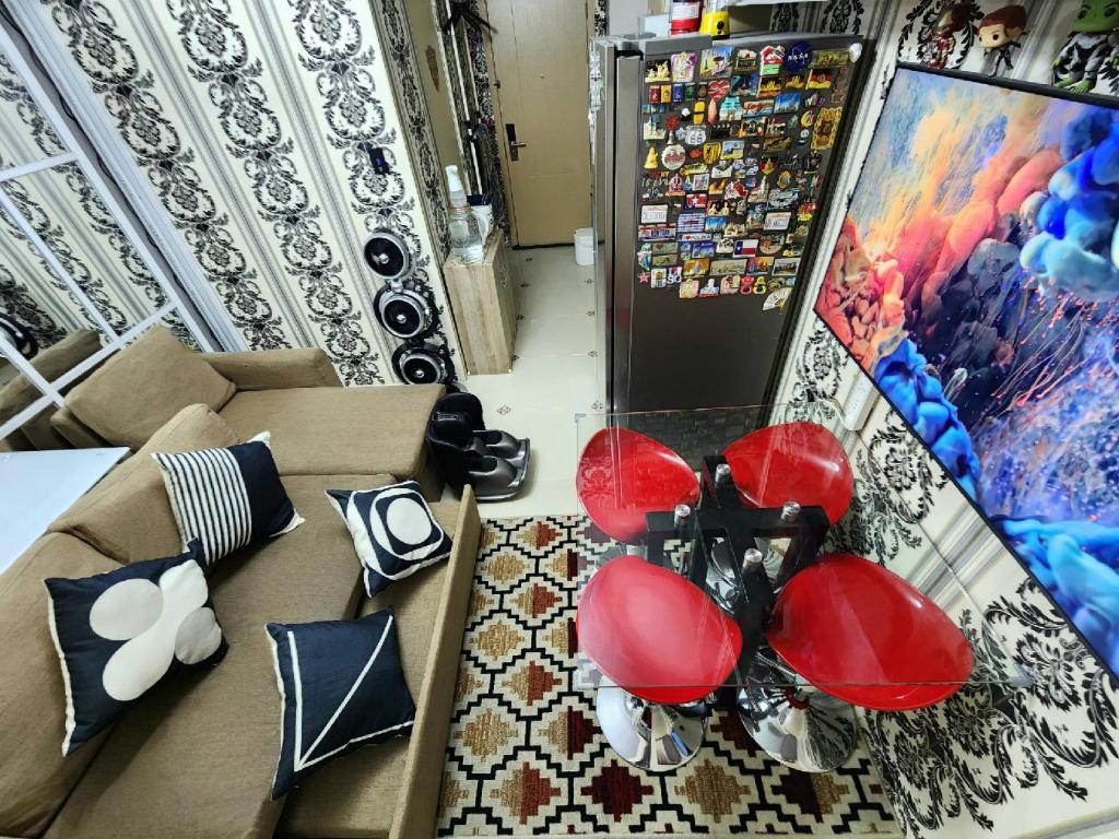 马尼拉High-Tech Studio at Grass Residences -2 persons only, Quezon City的带沙发和红色椅子的客厅