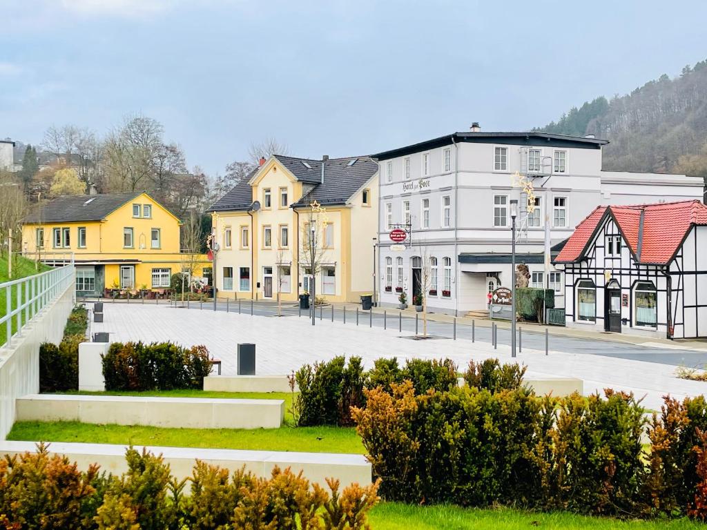 SchalksmühleHotel zur Post的街道上一座有黄色和白色建筑的城镇