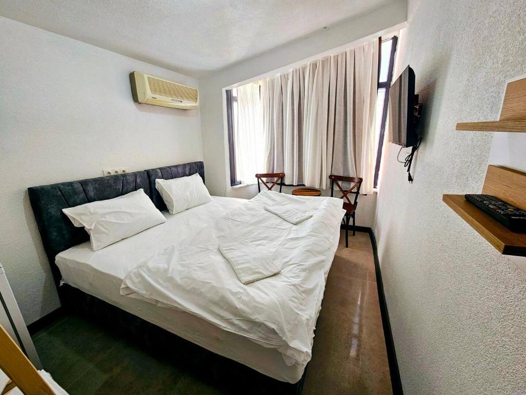 伊斯坦布尔Noya Suites的一间卧室配有一张带白色床单的床和一扇窗户。