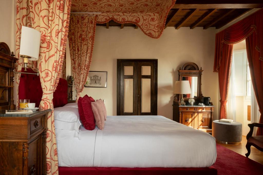 佛罗伦萨洛贾托迪赛维帝酒店的卧室配有一张带红色窗帘的大型白色床