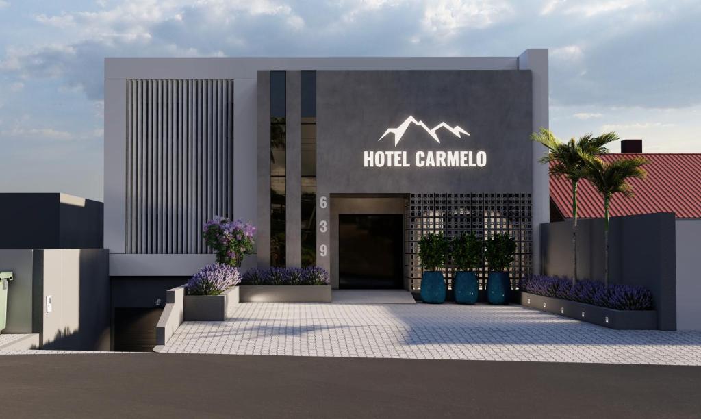 圣若泽杜斯皮尼艾斯Hotel Carmelo的一家酒店入口处的标志是读酒店,但被人蒙蔽