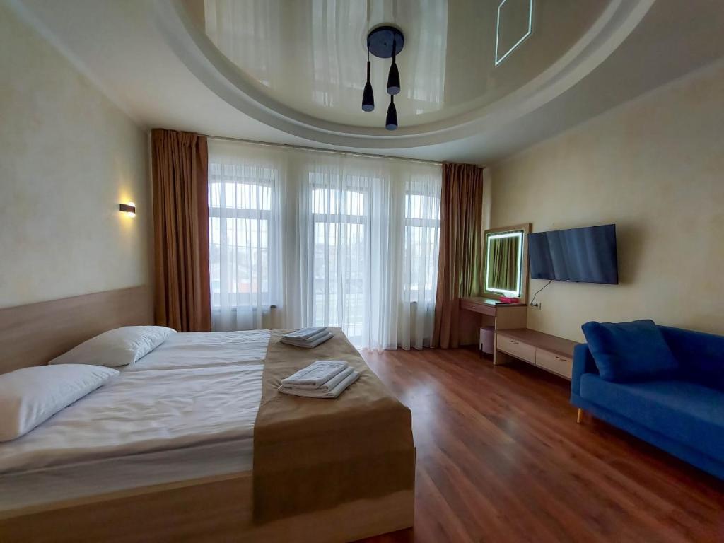 第聂伯罗Graff Hotel的一间卧室配有一张大床和一张蓝色的沙发