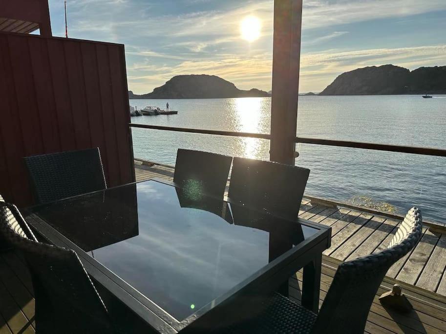 KorshamnNydelig ferieleilighet på bryggekanten的水边甲板上的桌椅