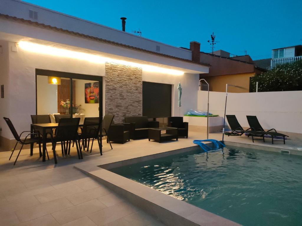 圣佩德罗-德尔皮纳塔尔Villamolinos, villa con piscina privada.的一个带桌椅的庭院和一个游泳池