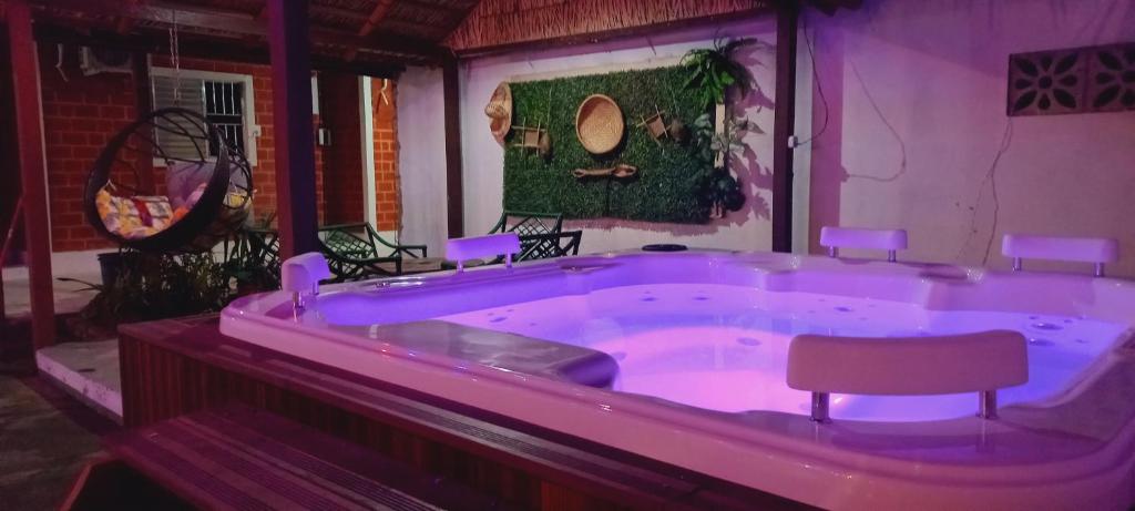 阿尔特杜尚Pousada Angatu alter的大型紫色浴缸,内配椅子