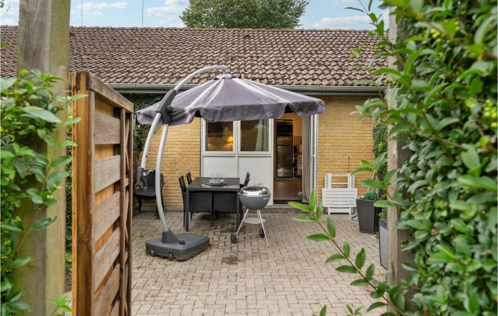 米泽尔法特Beautiful Apartment In Middelfart With Kitchen的一个带桌子和遮阳伞的庭院