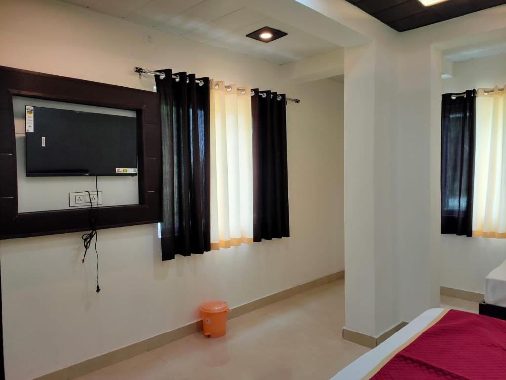 阿格拉Hotel Goyal Palace的卧室配有壁挂式平面电视。