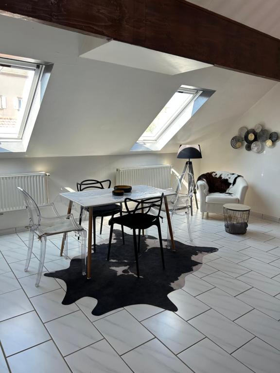 Spacieux duplex à Folschviller的客厅配有桌椅和天窗。