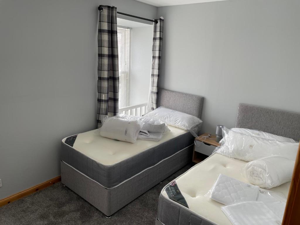 威克3 Bedroom Townhouse on NC500, Wick, Highland的一间卧室设有两张床和窗户。