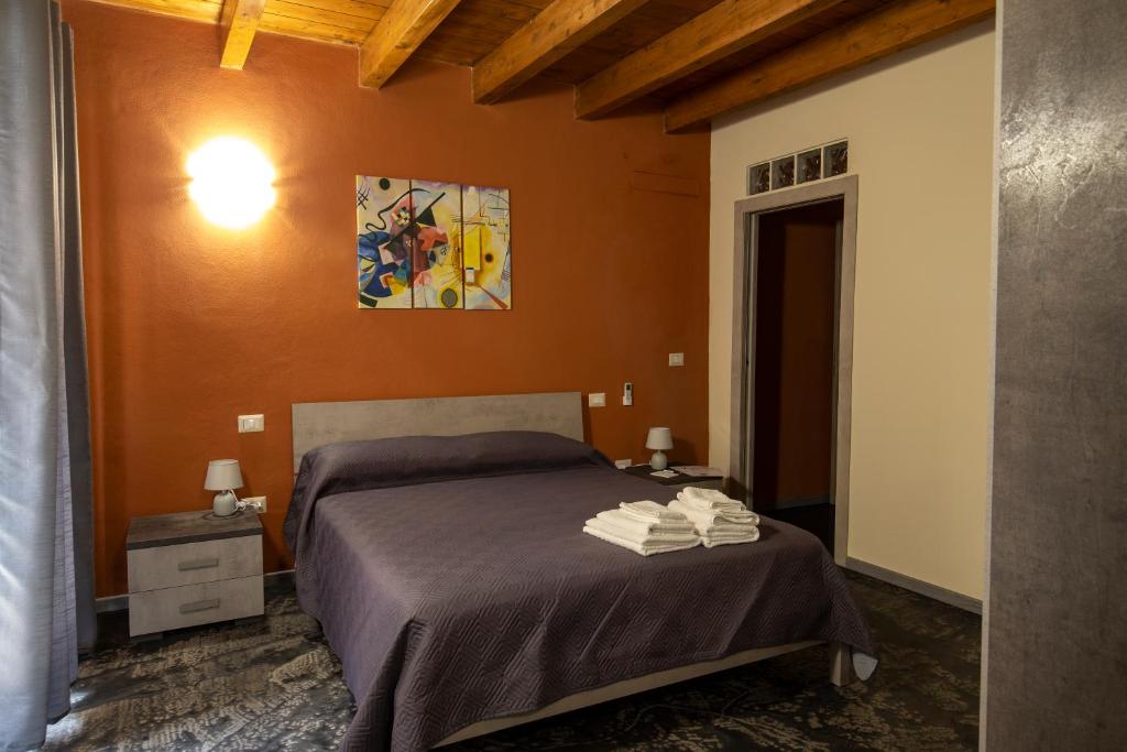 伊格莱西亚斯Via Cavour 19, Camere del Conte的卧室配有一张床,墙上挂有绘画作品