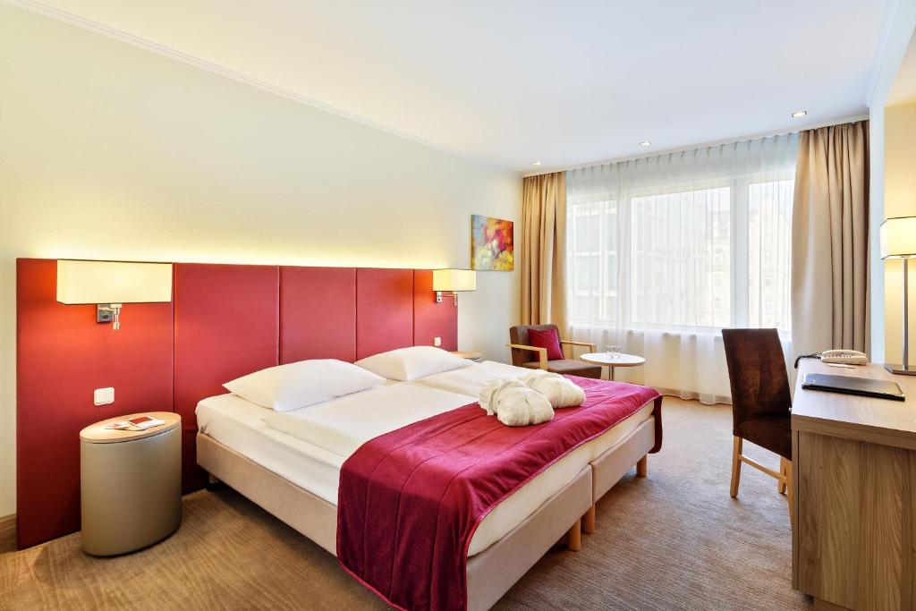 林茨Hotel Schillerpark Linz, a member of Radisson Individuals的一间卧室设有一张红色墙壁的大床