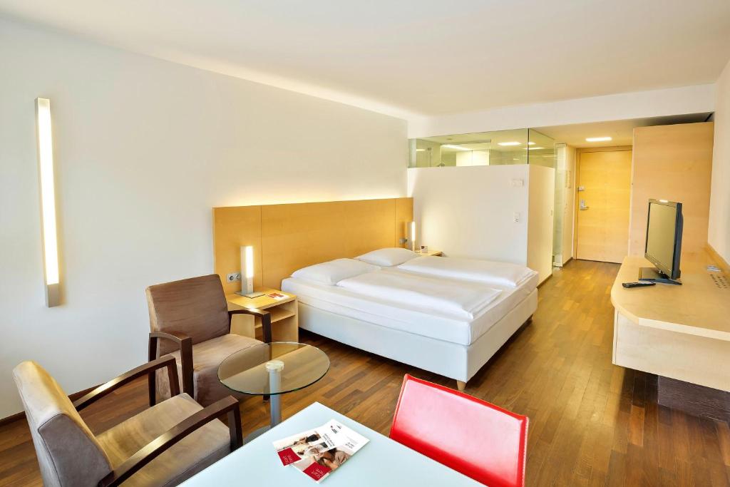 因斯布鲁克议会因斯布鲁克奥地利流行度假酒店的酒店客房设有床和客厅。