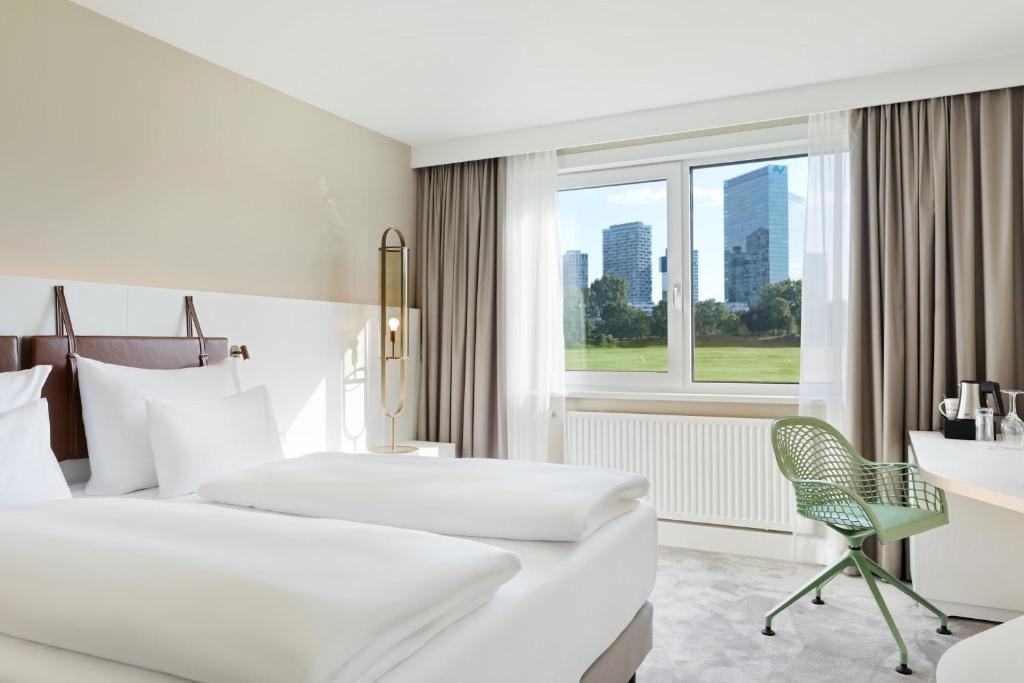 维也纳维也纳波塞奥地利时尚酒店的酒店客房设有两张床、一张书桌和一个窗户。