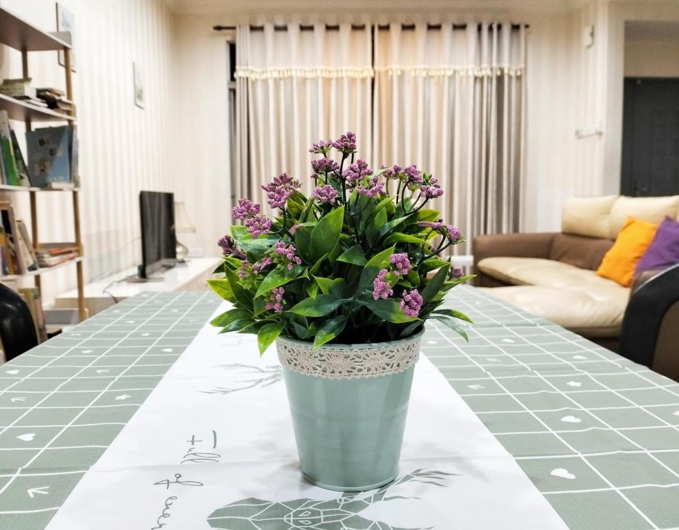新山JB Austin Perdana Homestay@Simple Comfy For 11pax的花瓶,花朵盛满紫色,坐在桌子上