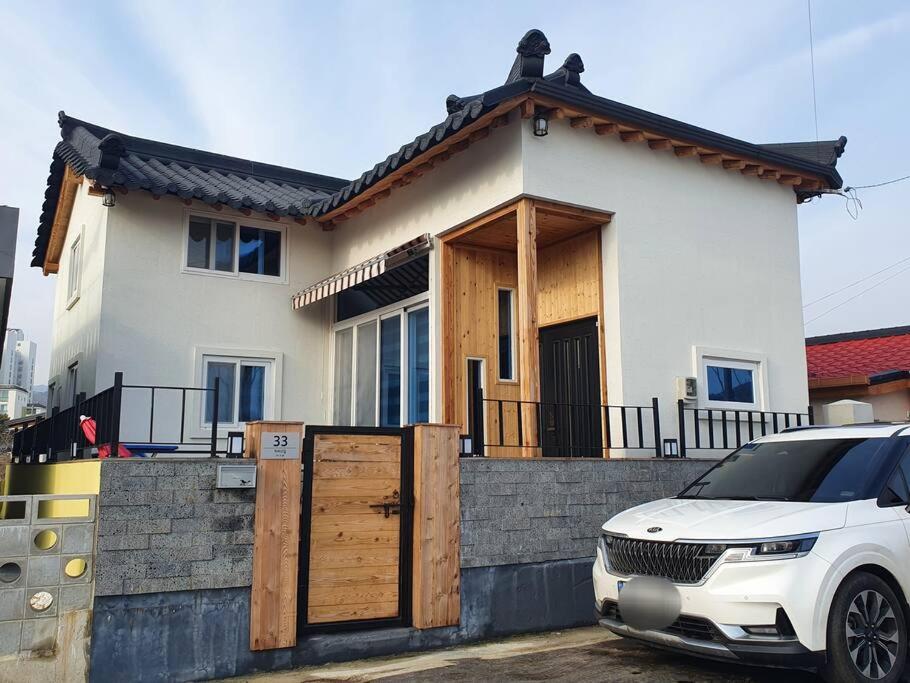 东海市Donghae Hanok Stay的停在房子前面的白色汽车