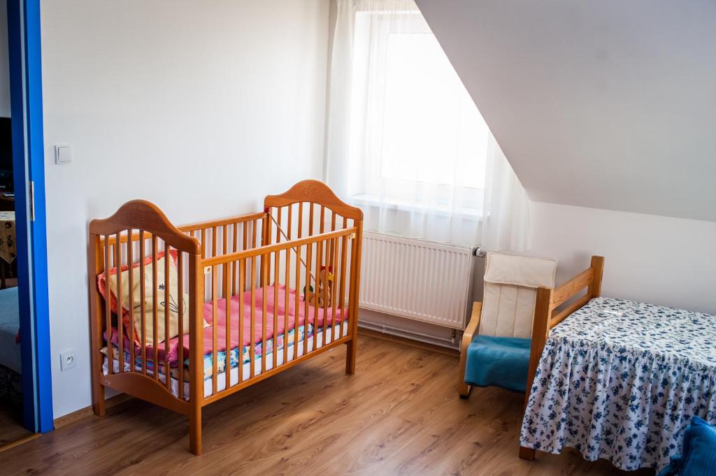 Batelov巴泰洛夫公寓的一间设有两张婴儿床、一张桌子和一个窗户的房间