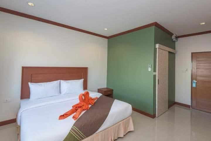 卡塔海滩Kata Noi Bay Inn的一间卧室配有一张带橙色丝带的大床