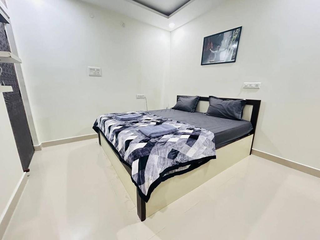 海得拉巴Bigson Service Apartments Gachibowli的一间白色客房内的床铺卧室