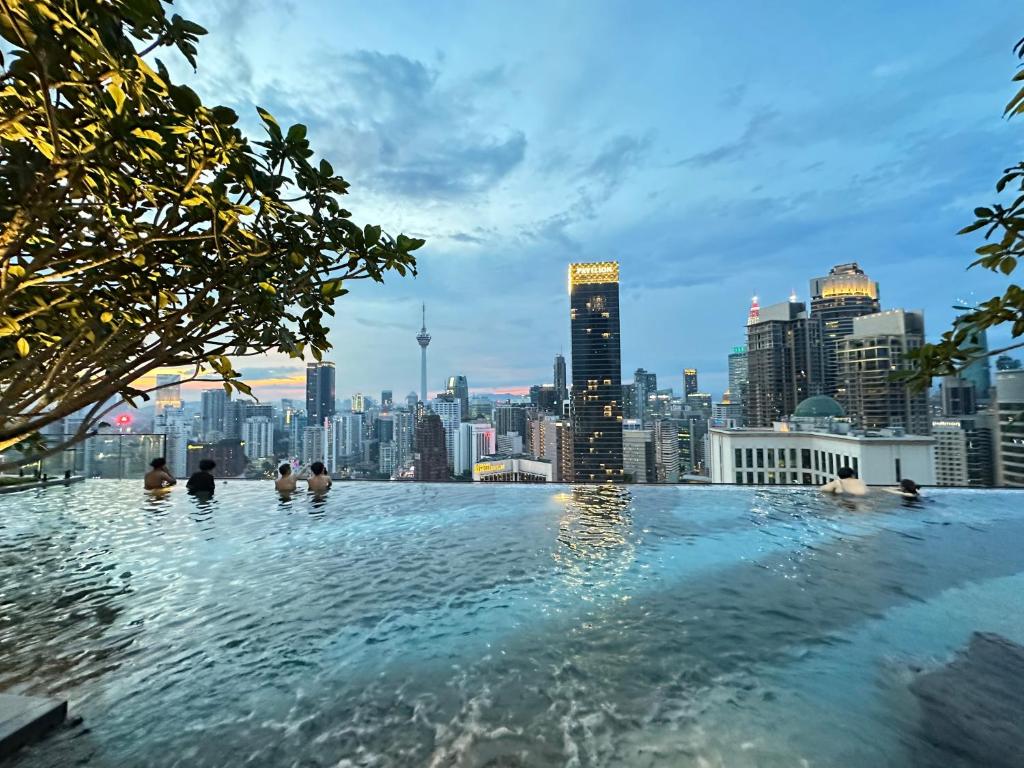 吉隆坡The Axon Bukit Bintang By Cozy White的一座以城市天际线为背景的无边泳池