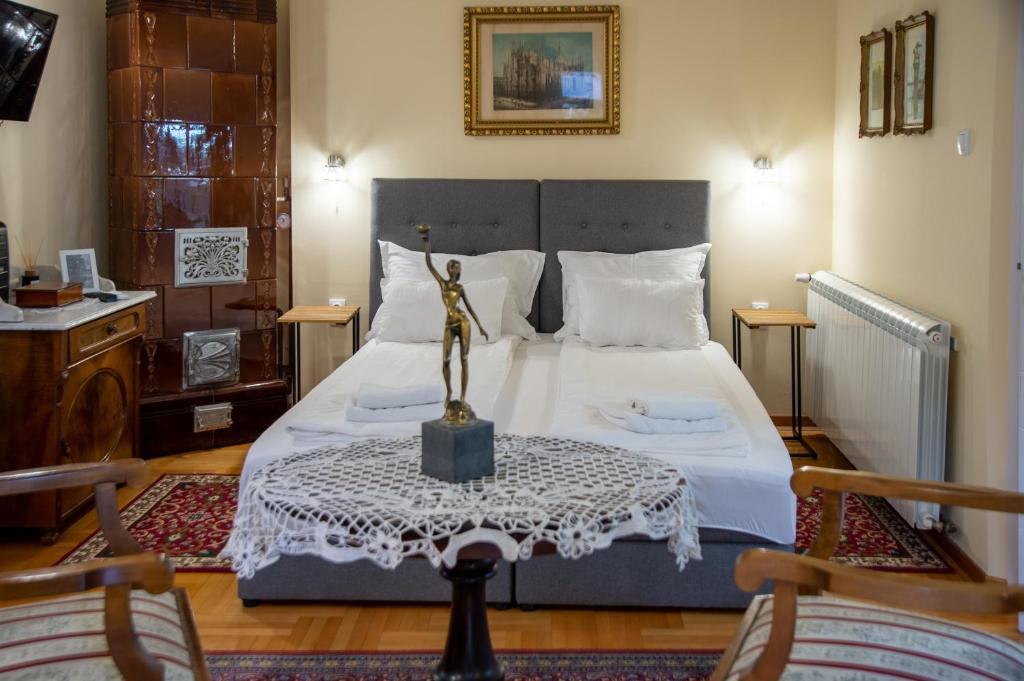 斯雷姆斯基卡尔洛夫奇Apartman Centar的一间卧室配有一张桌子上的雕像床
