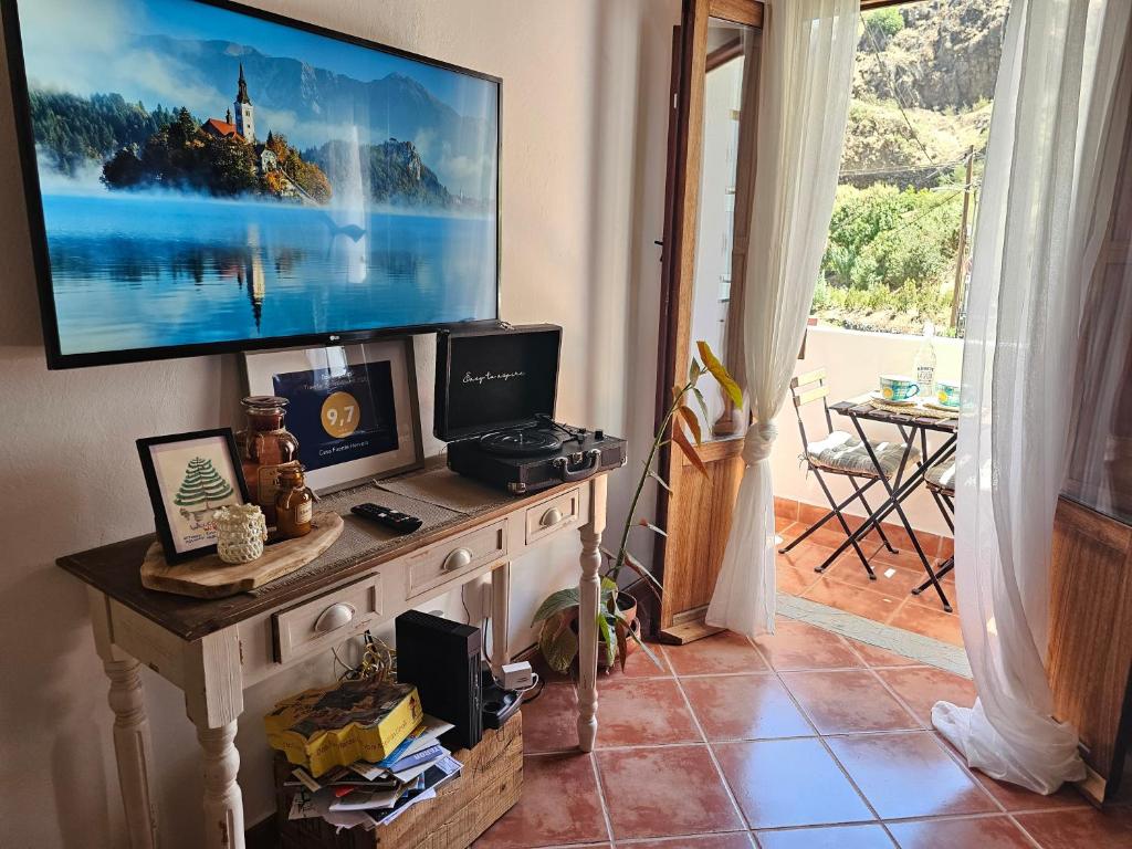 贝加德圣马特奥Casa Fuente Hervera的客厅配有桌子上方的电视
