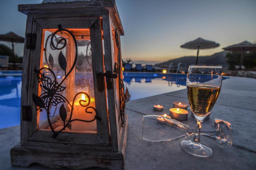 迈洛波塔斯安娜玛丽亚之家酒店的一杯葡萄酒和蜡烛放在池畔的桌子上