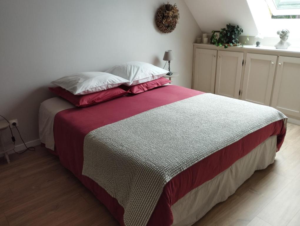 加来Le Clos des Mouettes的一间卧室配有一张带红白毯子的床