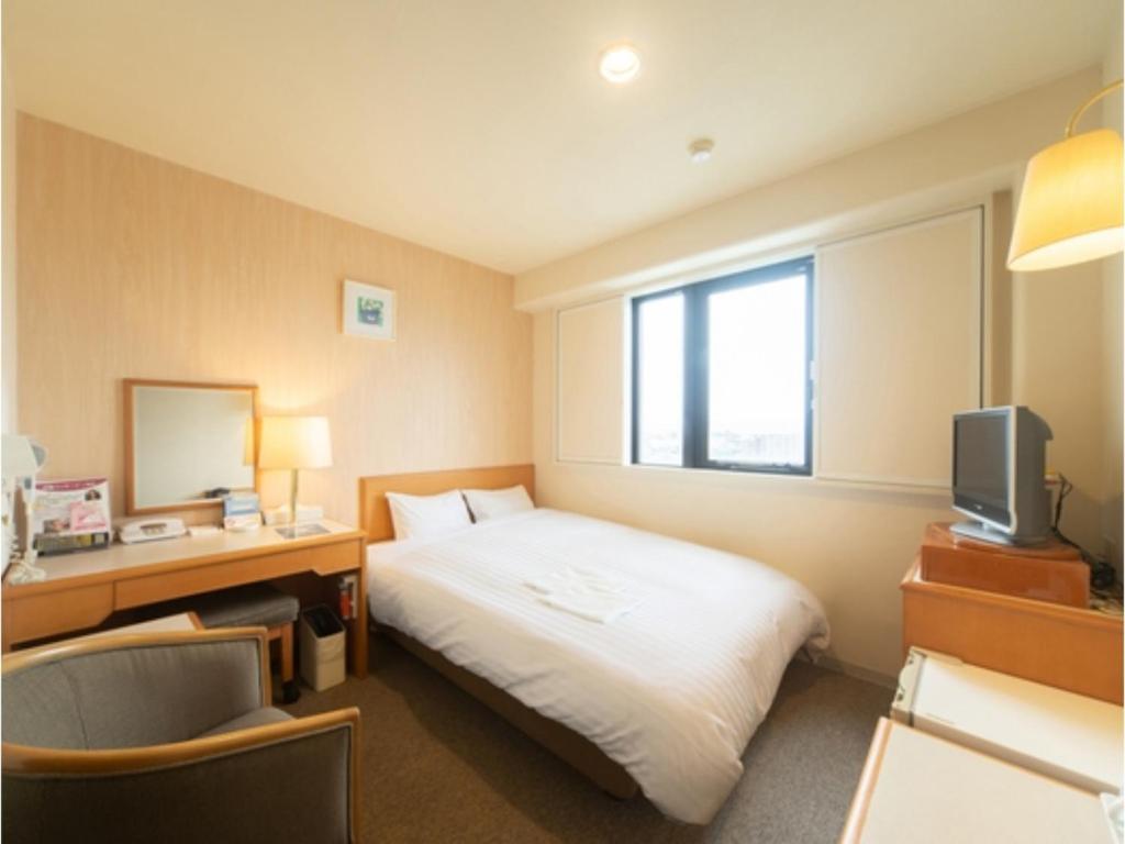 鸟栖市Sun Hotel Tosu Saga - Vacation STAY 49482v的酒店客房配有一张床、一张书桌和一台电视。
