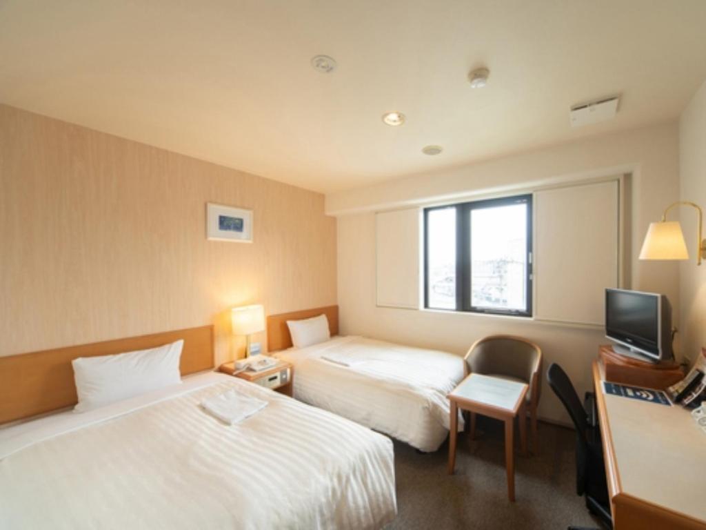 鸟栖市Sun Hotel Tosu Saga - Vacation STAY 49480v的酒店客房设有两张床和电视。