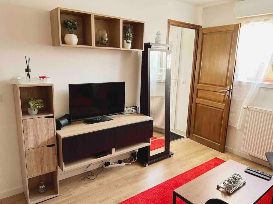 圣吉欧梅斯Appartement Ensoleillé à 15 minutes de Paris的客厅配有带书桌的平面电视