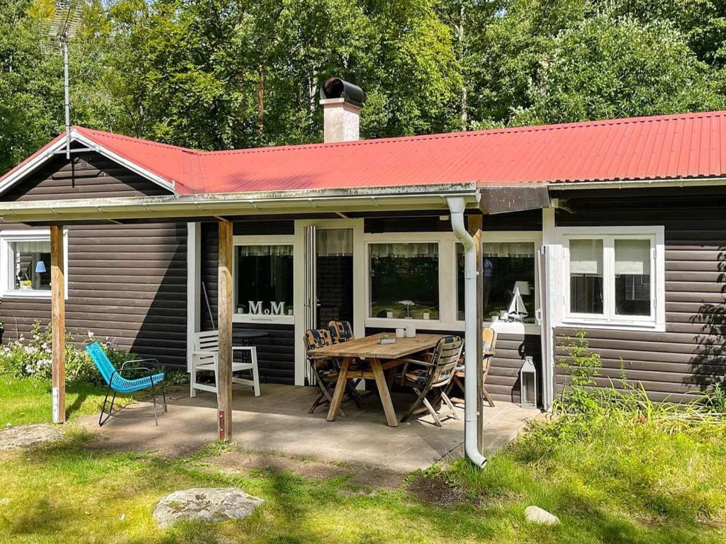 Lur4 person holiday home in H STVEDA的一座带野餐桌和红色屋顶的房子