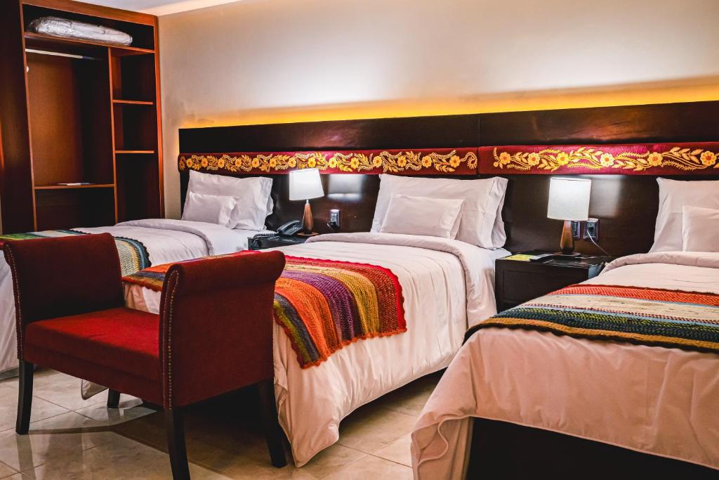 阿亚库乔Altipacha Ayacucho Hotel的酒店客房,配有两张床和椅子