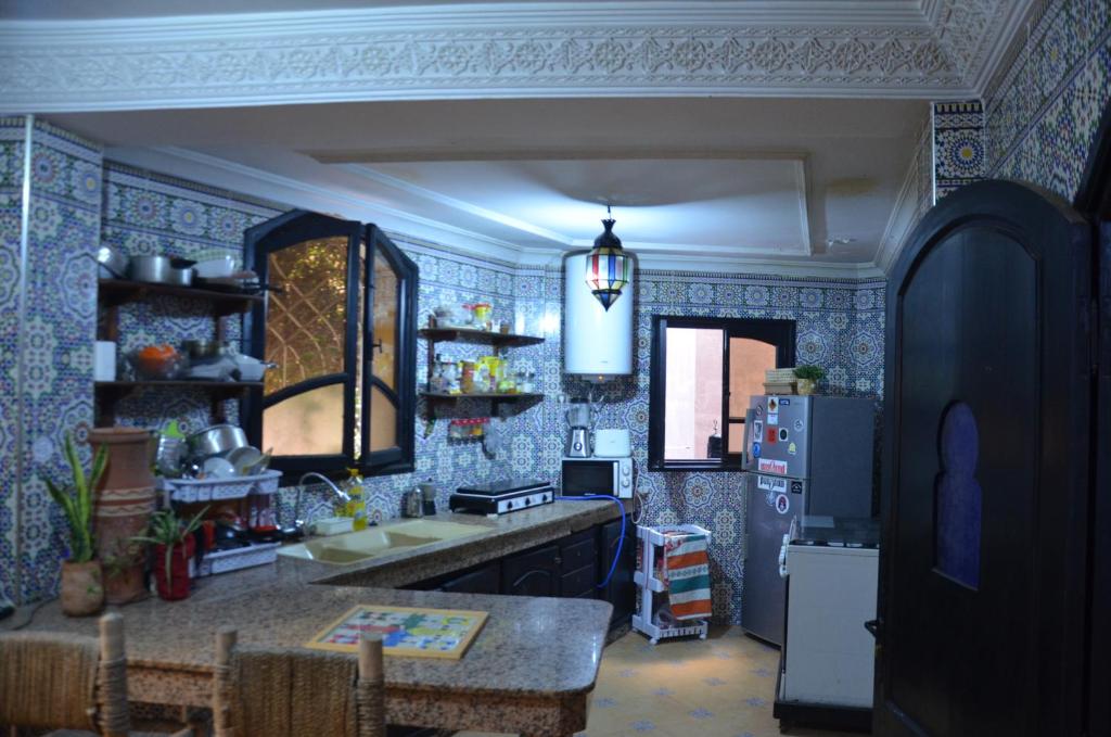 塔姆拉赫特乌兹达尔Arima Surf House的厨房设有蓝色瓷砖墙壁和冰箱。