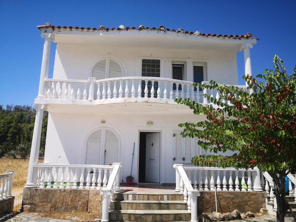 瓦西利卡Παραθαλάσσια εξοχική κατοικία的白色的房子,设有白色阳台和楼梯
