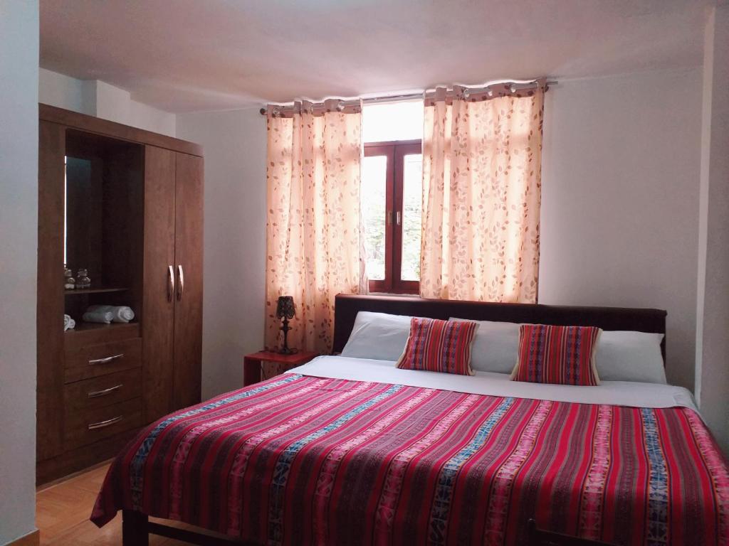 利马Chakana Family Home Lima Airport的一间卧室设有一张大床和一个窗户。