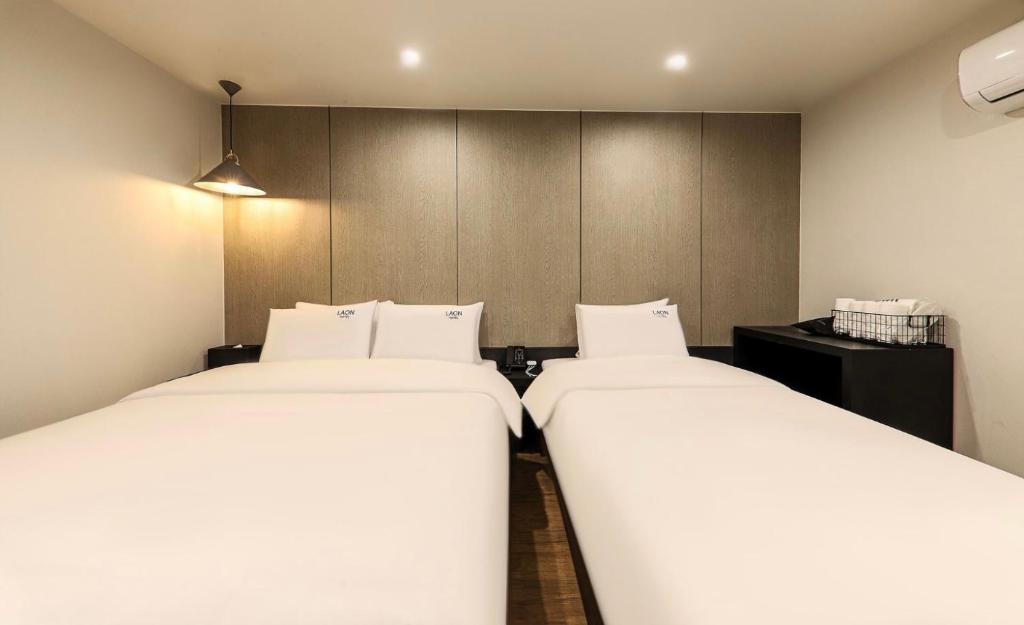 统营市Hotel Laon的配有2张单人床的带墙壁客房