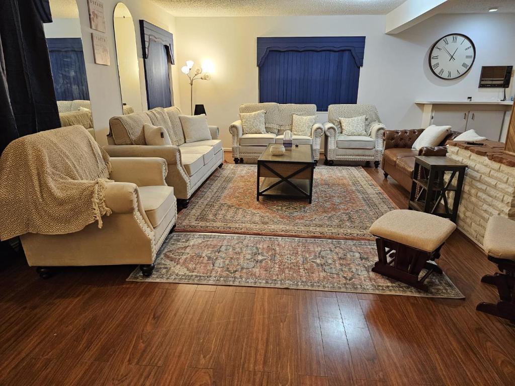 桑福德The Home的带沙发、椅子和时钟的客厅