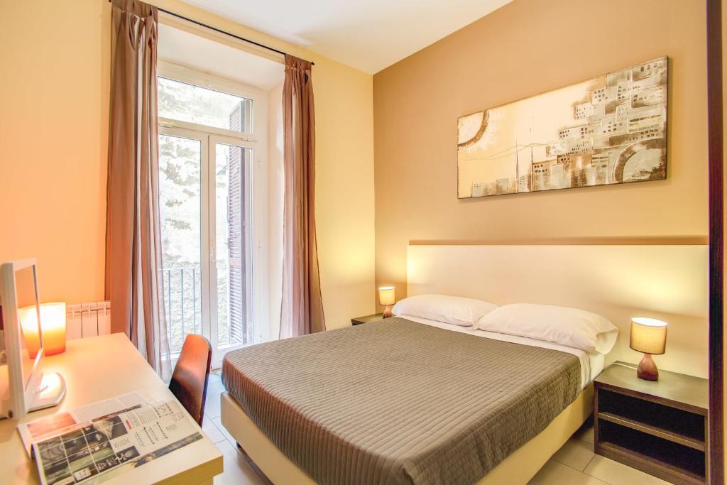 罗马罗马市中心马赛克酒店的一间卧室配有一张床、一张书桌和一个窗户。