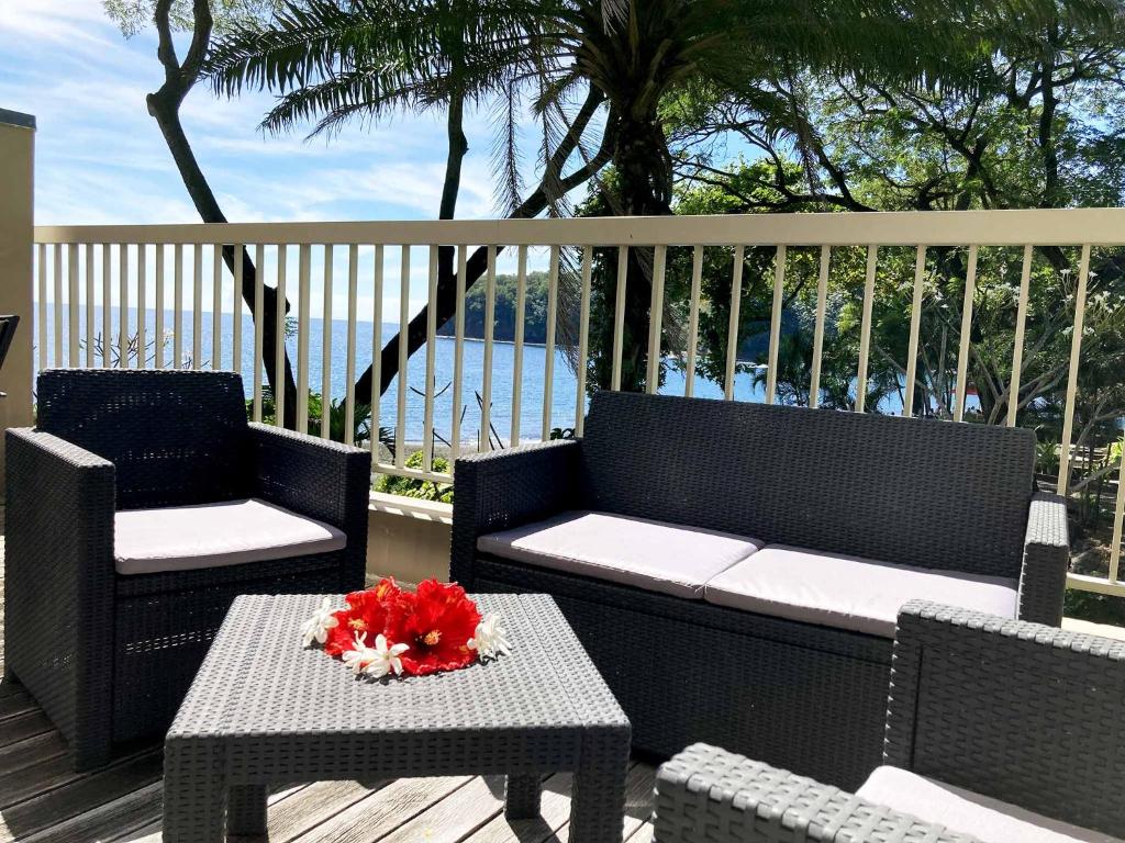 阿鲁埃Tahiti Lafayette Beach Lodge的天井配有两把椅子和一张带花卉的桌子