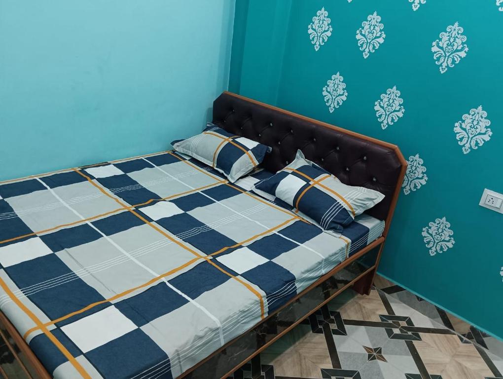 瓦拉纳西Laxman Guest House的蓝色墙壁间的一张床位