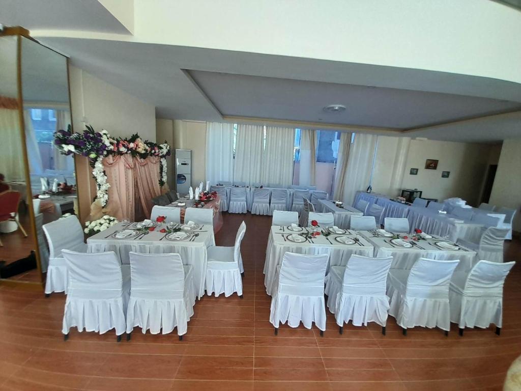 黎牙实比MaisonDeGloria的宴会厅配有白色的桌子和白色的椅子