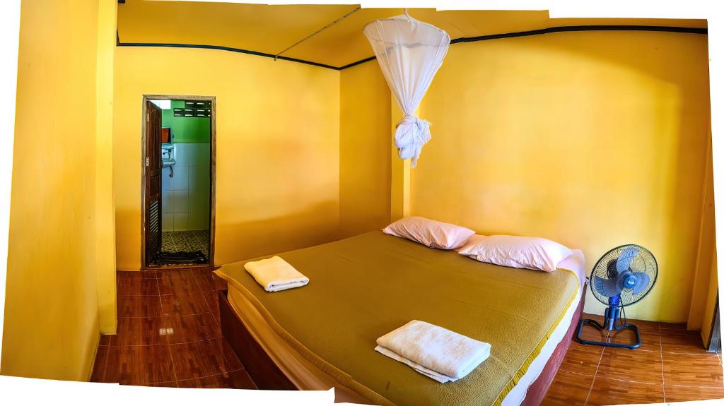 东德岛Don Det Sokxay and Mamapieng Budget Guesthouse的一间卧室配有一张带两条毛巾的床和风扇