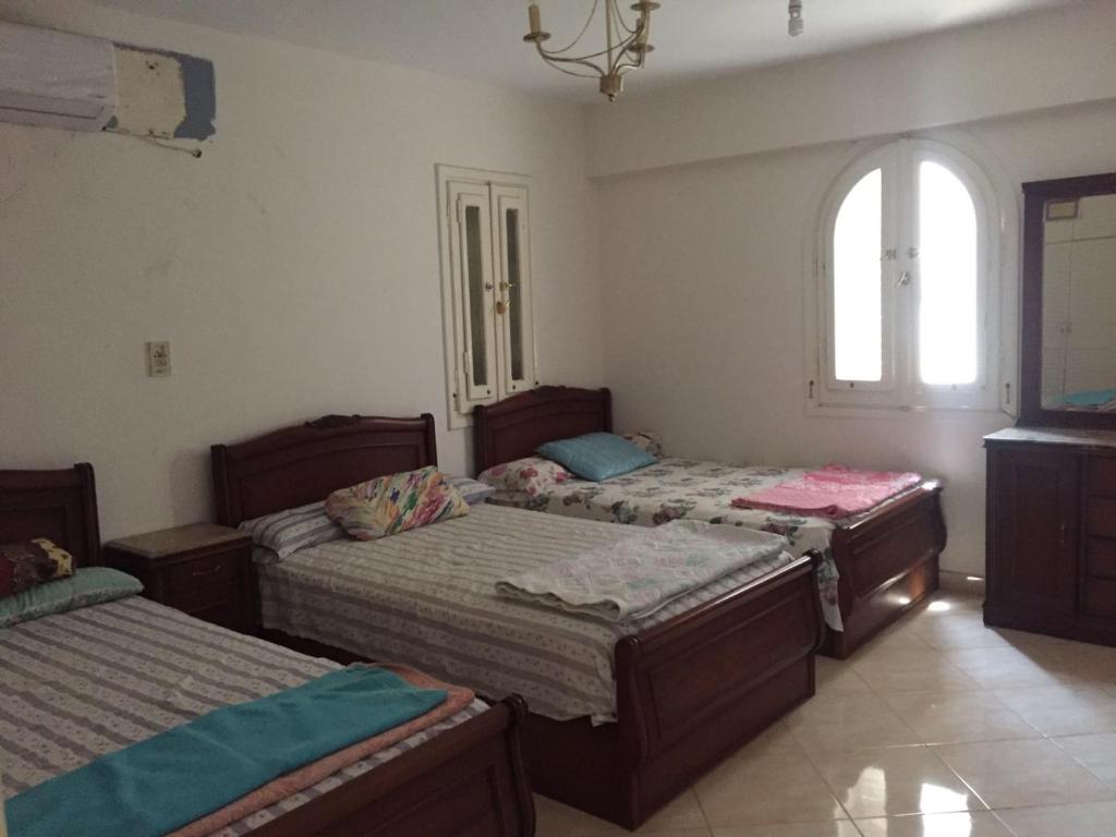 Abû Zeiraقرية سيدي كرير، القوات المسلحة الساحل الشمالي的一间卧室设有三张床和窗户。