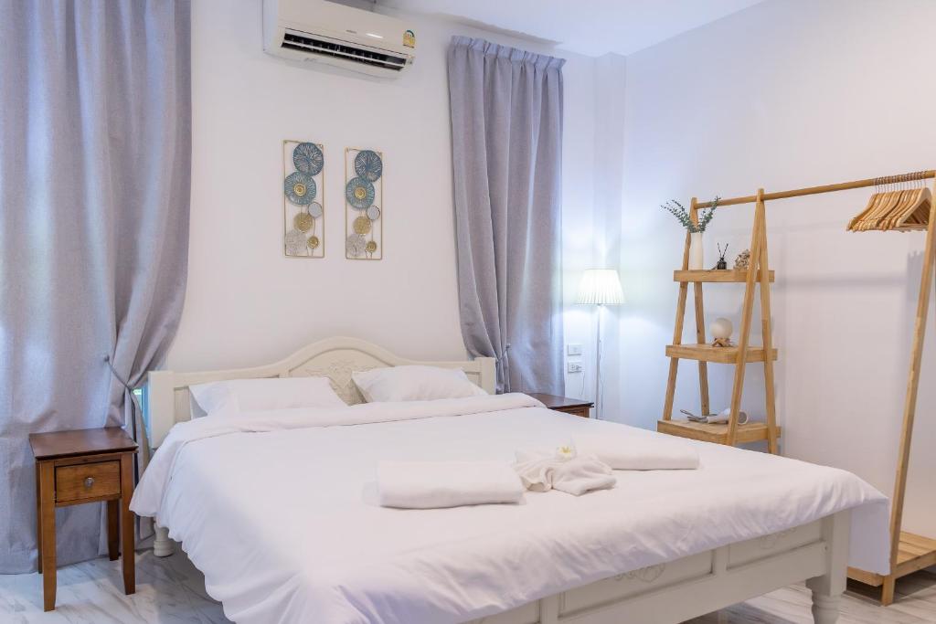Haad Chao PhaoApple Villas的卧室配有带毛巾的大型白色床