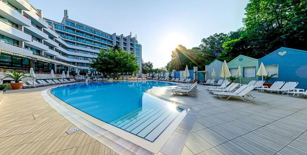 金沙MiRaBelle Hotel - Half Board Plus & All Inclusive的一座带躺椅的游泳池和一座建筑