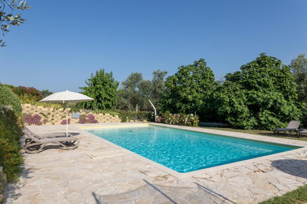Monte GibertoCasa Raffaela, Charming villa with a nice pool的一个带遮阳伞和椅子的游泳池