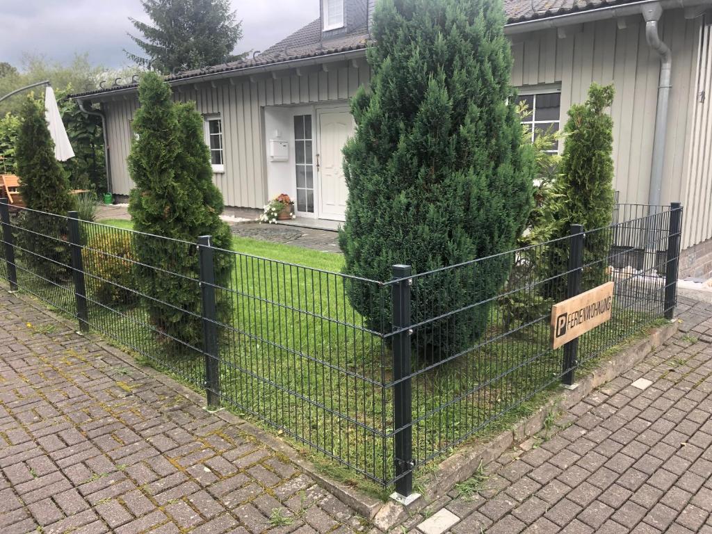 巴特贝勒堡Ferienwohnung am Rothaarsteig的房屋前有标志的栅栏