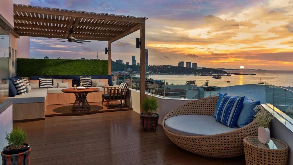 芭堤雅市中心芭提雅安凡尼度假酒店的阳台配有藤椅,享有水景。