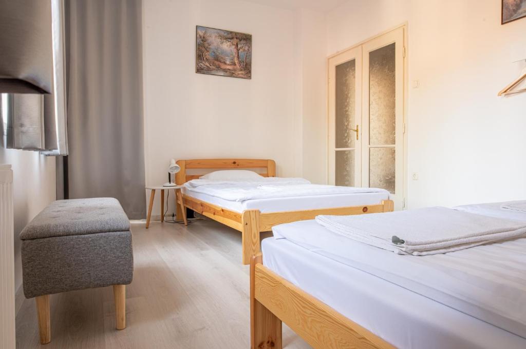 塞格德Barát Vendégház - Cosy Guesthouse - Teljes ház privát udvarral - 4 szoba, 2 fürdő的一间医院间,配有两张床和椅子