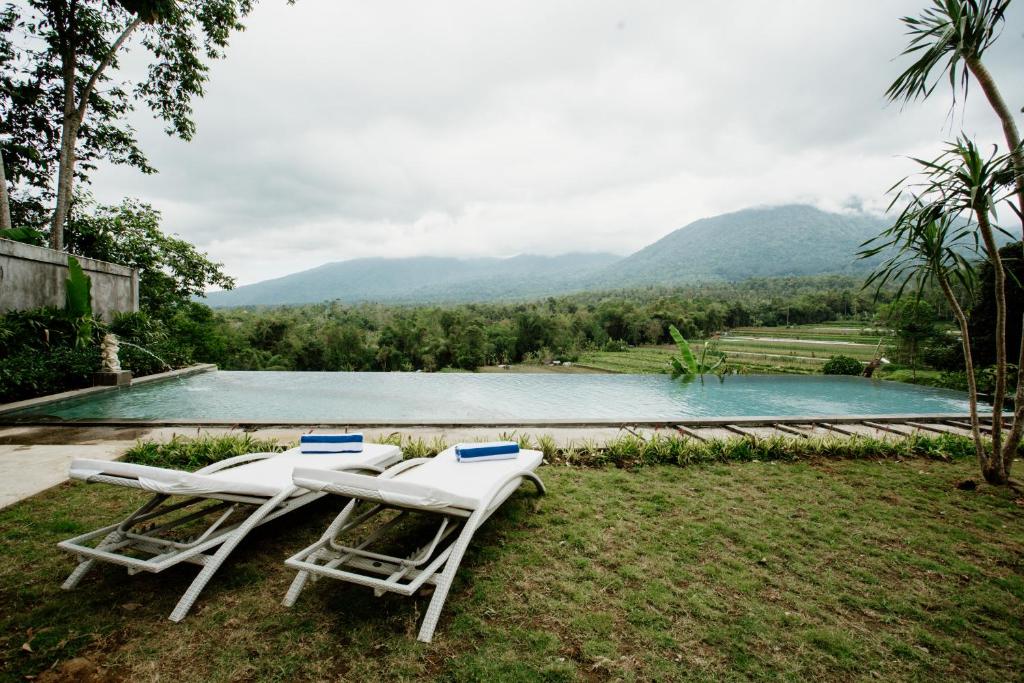 塔巴南Angseri Villas的两把椅子和一个山地游泳池